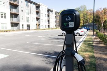 A parking meter in front of an empty parking lot